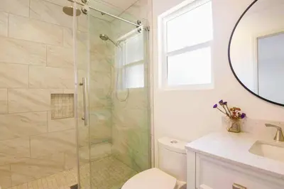 a bathroom with a shower and a toilet and a sink at The Cozy Oasis - A Renovated and Modern Studio near LAX + SoFi + Beaches + Freeway in Lawndale