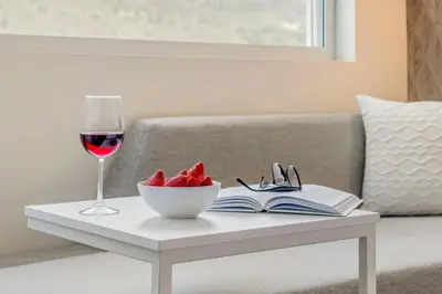 a glass of wine and a bowl of fruit on a table at Cambria Hotel Burbank Airport in Burbank