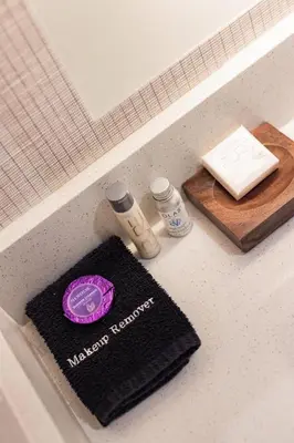 a bathroom counter with a sink with a towel and other items at Cambria Hotel Burbank Airport in Burbank