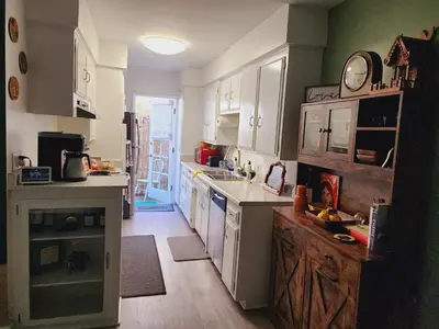 a kitchen with white cabinets and wooden floors at Cozy Private Room & Bath Central Location LA in Los Angeles