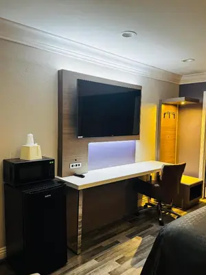 a room with a desk with a tv and a computer at Paradise Inn-Montebello,Los Angeles in Montebello