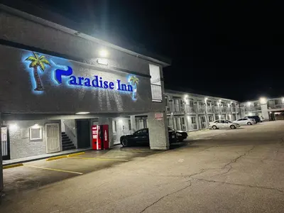 a parking lot in front of a parakeet inn at night at Paradise Inn-Montebello,Los Angeles in Montebello