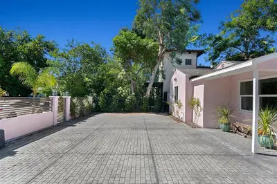 a driveway of a pink house with a fence at Lovely North Hollywood House Near Universal in North Hollywood