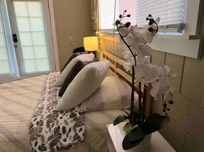 a bedroom with a bed and a vase with flowers at Bonito descanso LAX 10 min SOFI 5 min in Hawthorne