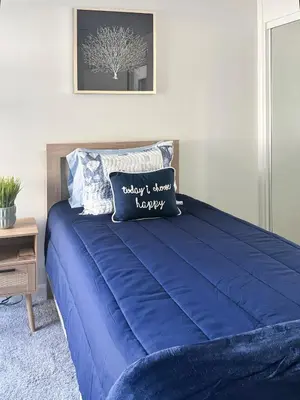 a blue bed with two pillows on top of it at Quaint Mid-Century Cottage by the Coast in Ventura