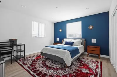 a bedroom with a bed and a blue wall at Good Shepard Homestay in Los Angeles