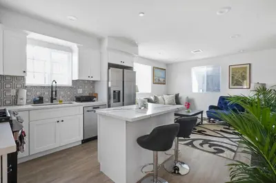 a kitchen and living room with white cabinets and a bar at Good Shepard Homestay in Los Angeles