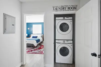 a laundry room with two washing machines and a bed at Good Shepard Homestay in Los Angeles