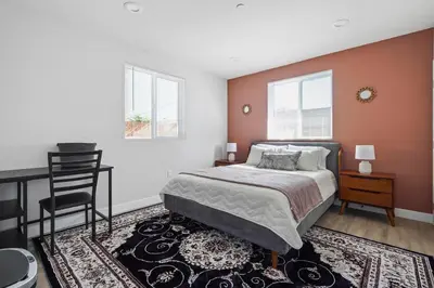 a bedroom with a bed and a desk and a chair at Good Shepard Homestay in Los Angeles