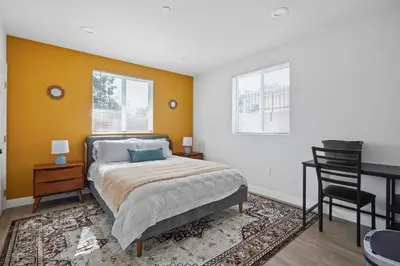 a bedroom with a bed and a desk and a chair at Good Shepard Homestay in Los Angeles