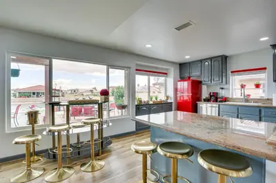a kitchen with a large counter with stools and a red refrigerator at Family Helendale Home - Private Dock and Fire Pit! in Helendale
