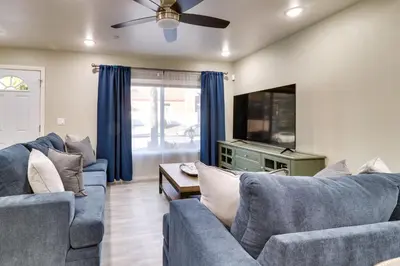 a living room with two blue couches and a flat screen tv at Fast WiFi and Free Parking Cozy Fontana Apartment in Fontana