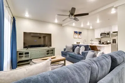 a living room with two blue couches and a flat screen tv at Fast WiFi and Free Parking Cozy Fontana Apartment in Fontana