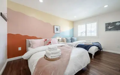a bedroom with two beds and a table at Elegant Retreat w/ Game room in Heart of OC in Midway City