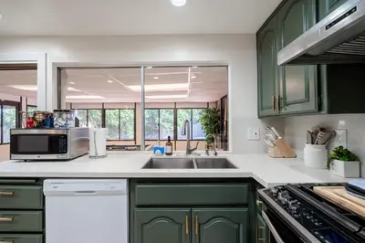 a kitchen with green cabinets and a sink at Elegant Retreat w/ Game room in Heart of OC in Midway City