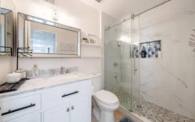 a bathroom with a shower and a toilet and a sink at Elegant Retreat w/ Game room in Heart of OC in Midway City