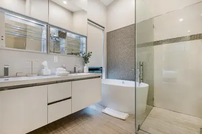 a white bathroom with a tub and a glass shower at Coldwater Canyon in Los Angeles
