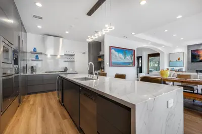 a kitchen with a large white counter and a dining room at Escondido Escape in Malibu