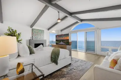 a bedroom with a white bed and a large window at Escondido Escape in Malibu