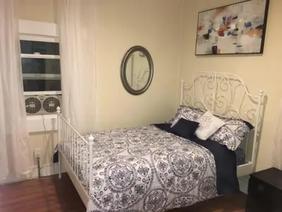 a bedroom with a bed and a mirror on the wall at DTLA Oasis Private Bedroom with Exclusive Laundry - Steps to the Heartbeat of LA in Los Angeles