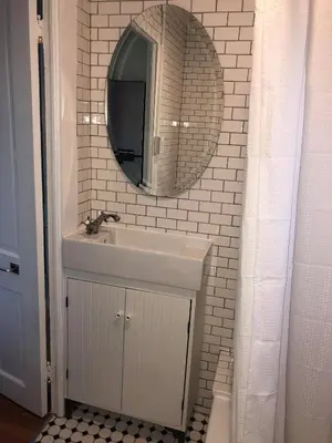 a white bathroom with a sink and a mirror at DTLA Oasis Private Bedroom with Exclusive Laundry - Steps to the Heartbeat of LA in Los Angeles