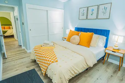 a blue bedroom with a bed with orange pillows at Retreat Minutes To LAX, Manhattan/ Redondo Beach in Torrance