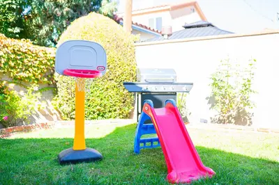 two childrens play equipment in a yard with a grill at Retreat Minutes To LAX, Manhattan/ Redondo Beach in Torrance