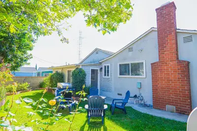 a yard with chairs and a table and a house at Retreat Minutes To LAX, Manhattan/ Redondo Beach in Torrance