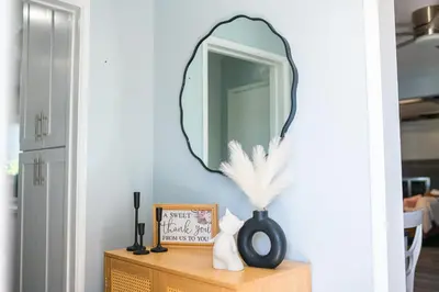 a mirror on a wall above a wooden dresser at Retreat Minutes To LAX, Manhattan/ Redondo Beach in Torrance