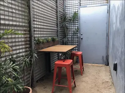 a table and two red stools in a room with plants at Dogtown Loft in Los Angeles