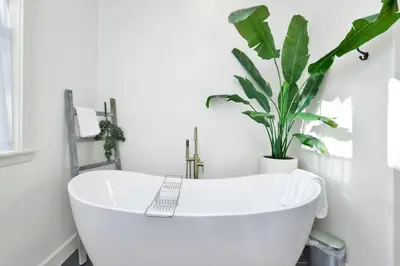 a white bath tub in a bathroom with a plant at Pine Meadow Village Castle~ Incredible Chalet Home in Big Bear Lake