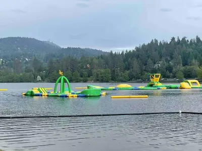 a group of inflatable water rides on a lake at Beautiful, family friendly cabin by Lake Gregory. in Crestline