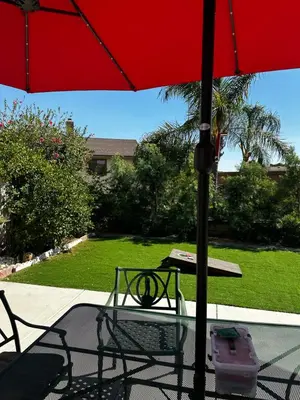 a table with a red umbrella on a patio at Buxton Room in Rialto