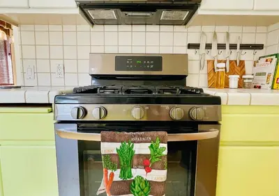 a kitchen with a stove with a towel on it at 2 BR 2 BA - Eco House and Garden Vacation Retreat and Remote Workspace for Families, Couples and Solo Travelers in Coveted Culver in Culver City