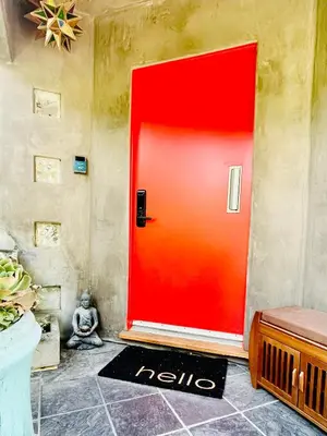 a red door with a person sitting in front of it at 2 BR 2 BA - Eco House and Garden Vacation Retreat and Remote Workspace for Families, Couples and Solo Travelers in Coveted Culver in Culver City