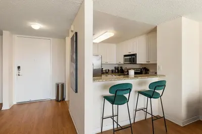 a kitchen with two green chairs at a counter at Amber Tide - Bright 1BR Marina Gem Ocean View in Los Angeles