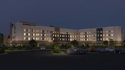 a large building with cars parked in a parking lot at Staybridge Suites Eastvale - Norco by IHG in Eastvale
