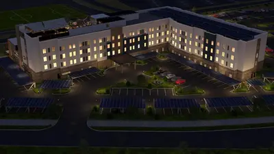 an overhead view of a building with solar panels in a parking lot at Staybridge Suites Eastvale - Norco by IHG in Eastvale