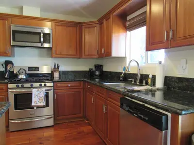 a kitchen with wooden cabinets and stainless steel appliances at Smith Lakefront Hideaway in Big Bear Lake