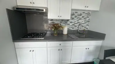a kitchen with white cabinets and a stove and a sink at AB&B suite in Chino Hills