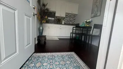 a hallway with a kitchen and a door with a rug at AB&B suite in Chino Hills
