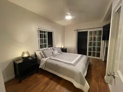 a bedroom with a large bed and two windows at Your home away from home in beautiful Santa Monica in Los Angeles