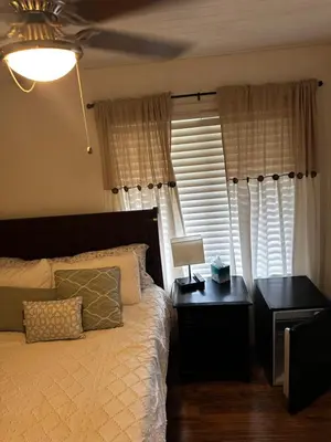 a bedroom with a bed and a desk and a window at Buxton Mirror Room in Rialto