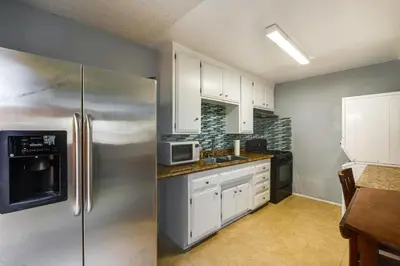 a kitchen with white cabinets and a stainless steel refrigerator at 3 Mi to Universal Studios North Hollywood Home in North Hollywood