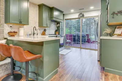 a kitchen with green cabinets and a hardwood floor at Cozy Wrightwood Cabin Family and Pet Friendly! in Wrightwood