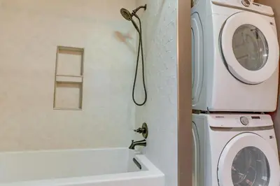 a washing machine in a bathroom next to a washer at Cozy Wrightwood Cabin Family and Pet Friendly! in Wrightwood