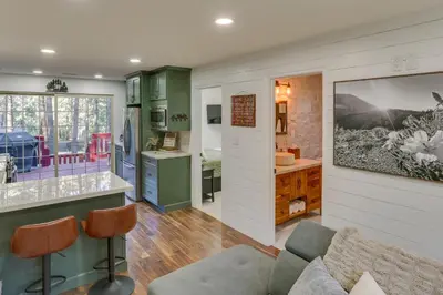 a kitchen and living room with green cabinets at Cozy Wrightwood Cabin Family and Pet Friendly! in Wrightwood