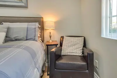 a bedroom with a bed and a chair and a lamp at Cozy Simi Valley Studio Less Than 10 Mi to Hiking and Golf in Simi Valley