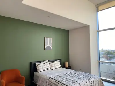 a green bedroom with a bed and a chair at Spacious and Stylish unit in Los Angeles