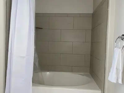 a white bath tub with a shower curtain in a bathroom at Spacious and Stylish unit in Los Angeles